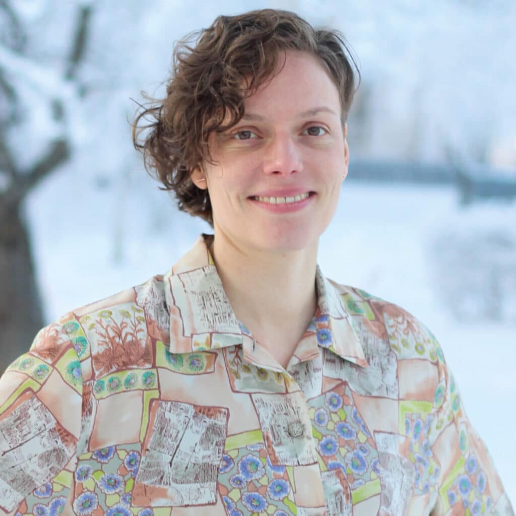 Porträttbild på inflyttarlotsen Hilde. Kvinna med lockigt brunt hår.