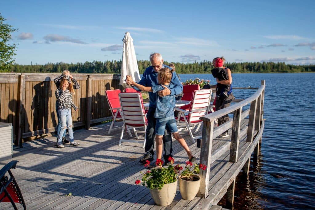 Äldre man och barn dansar på brygga.