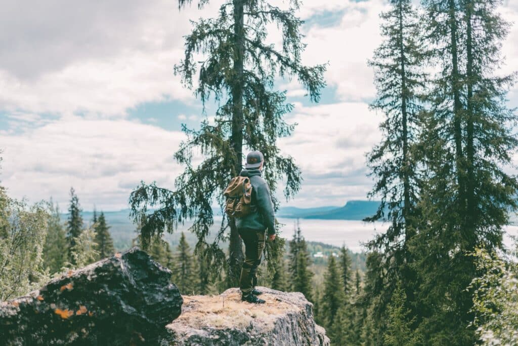 Vandrare som står på en klippa och blickar ut över vyn